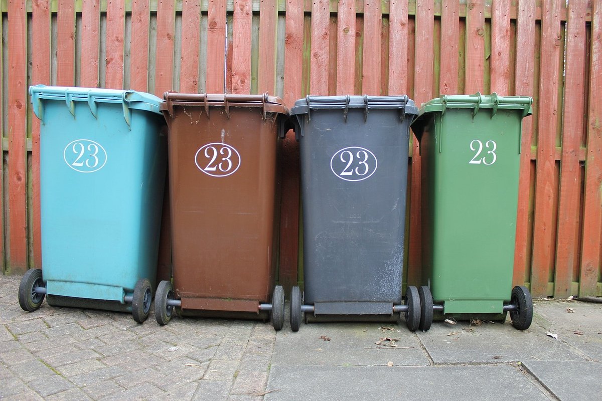 Photo montrant 4 containers (bleu clair, marron, gris et vert)