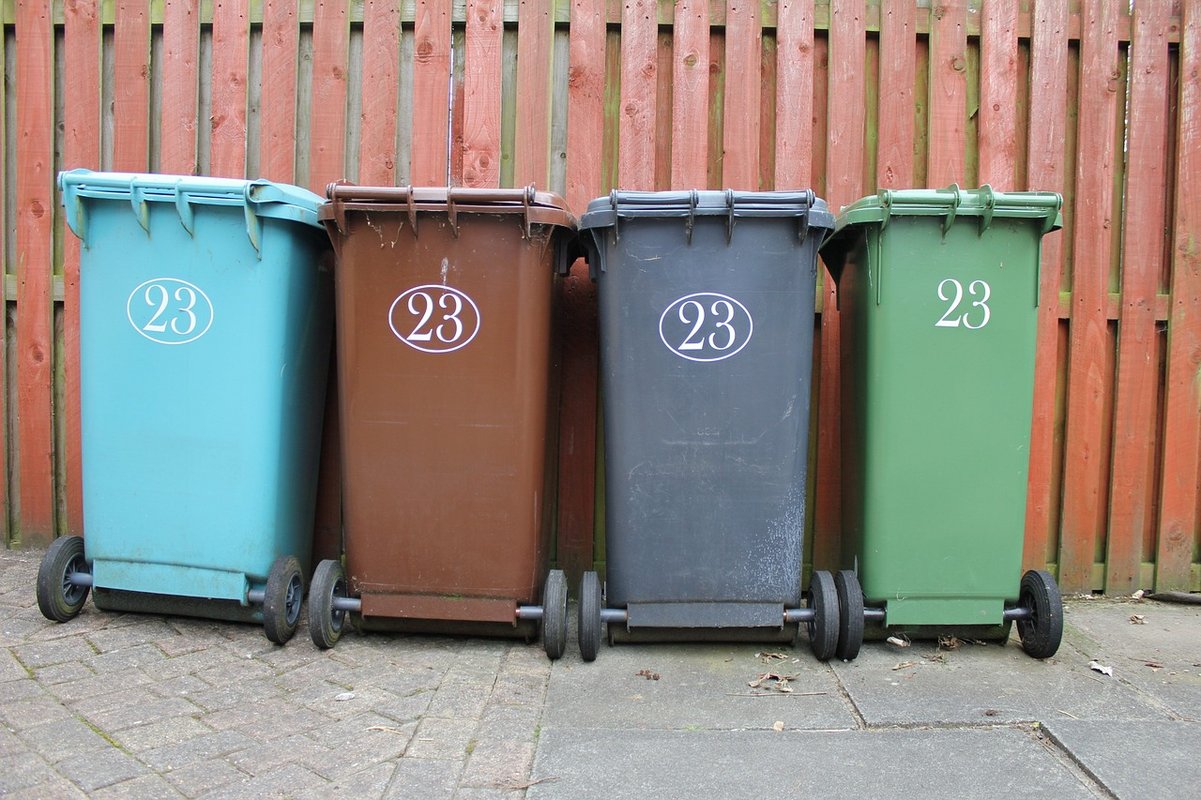 Photo montrant 4 containers (bleu clair, marron, gris et vert)